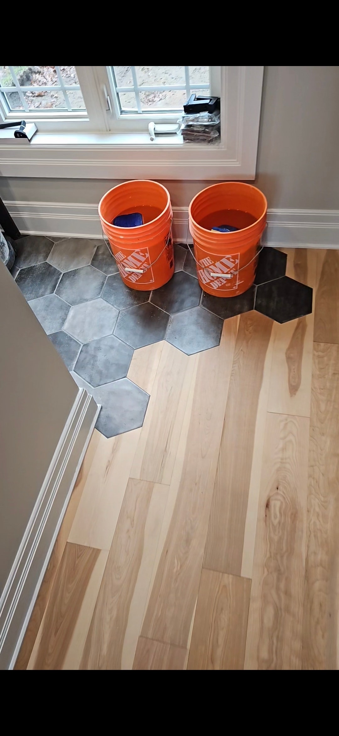 Custom hexagonal tile flooring transitioning to hardwood