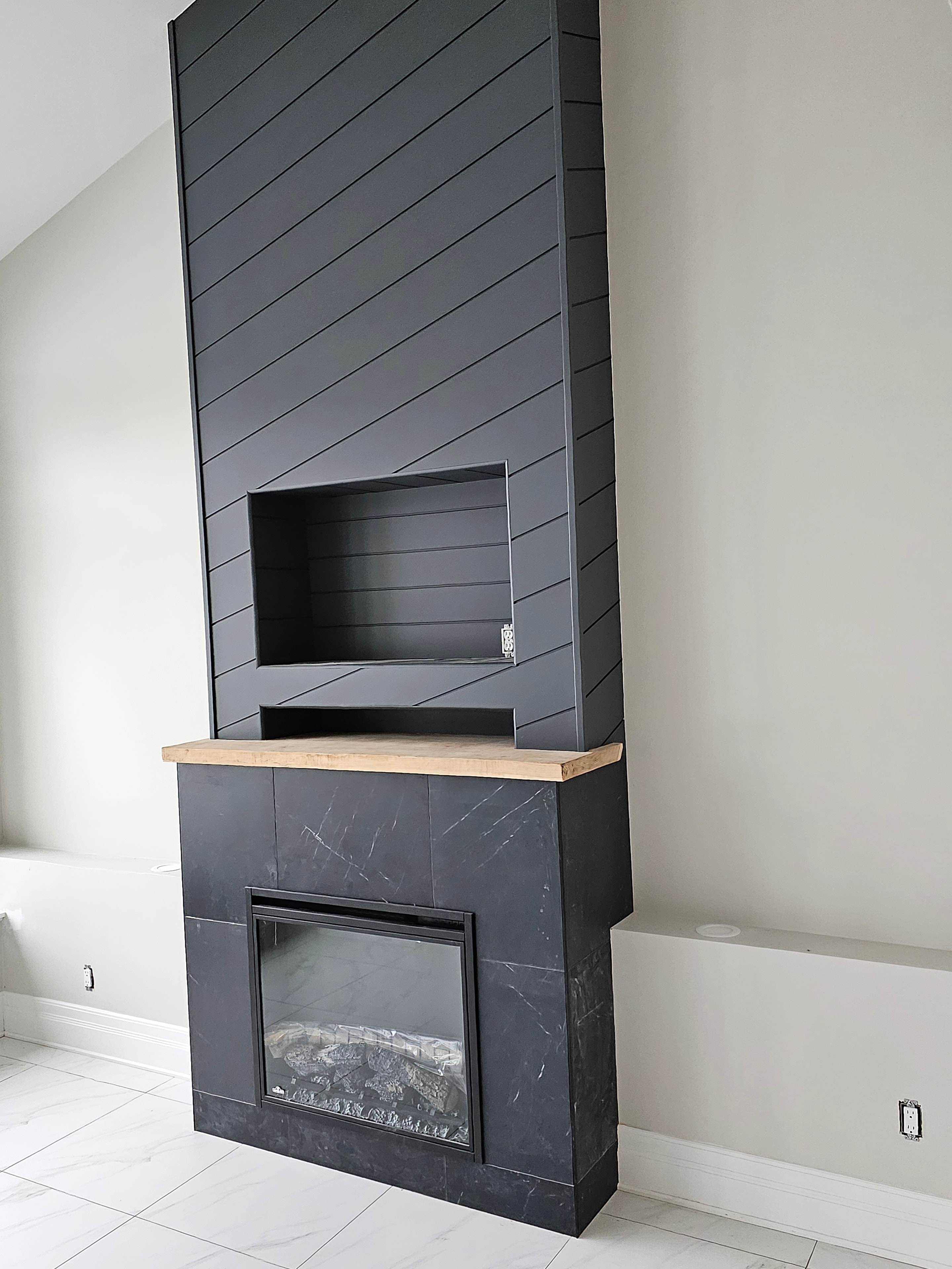 Custom dark tile feature wall with built-in fireplace